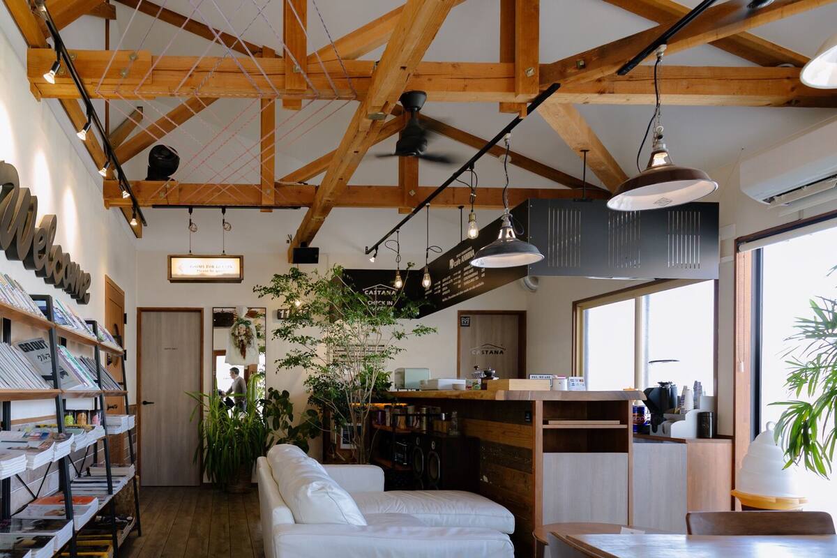 A cozy interior with wooden beams, a white sofa, and a coffee bar.