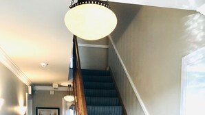 A staircase with patterned carpet, wooden handrails, and a light fixture above. - Westwinds (Galway)