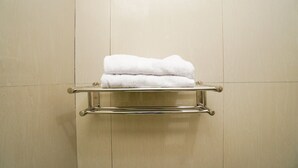 Une salle de bain avec un porte-serviettes sur lequel sont pliées des serviettes.