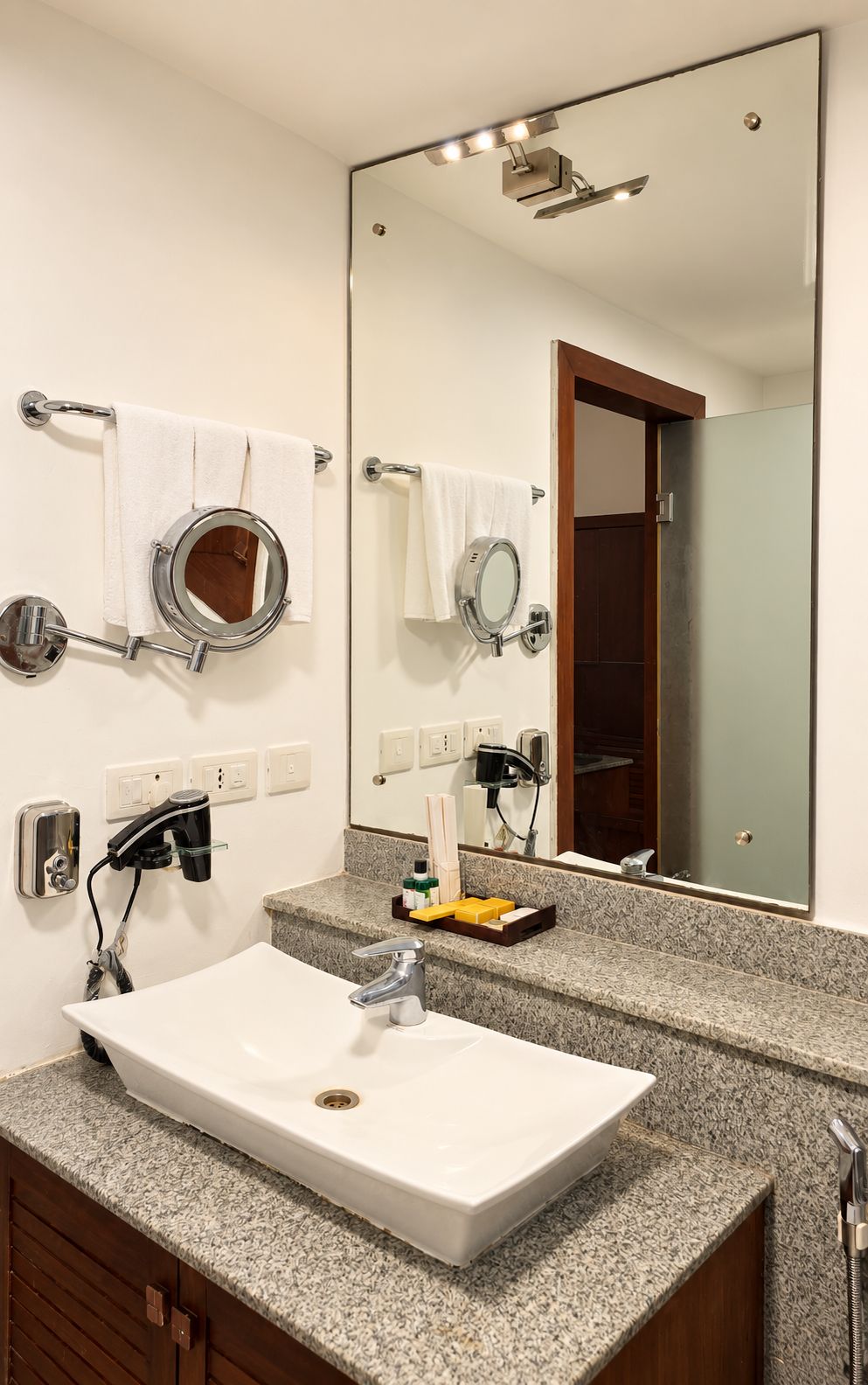 A bathroom with a white sink, a large mirror, and a towel rack.
