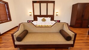 Un dormitorio con una cama, un armario de madera y un sofá.