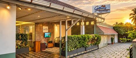 A beach resort with a covered entrance, reception desk, and outdoor seating area.