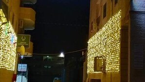 A sign for Al Walji Towers with illuminated text in Arabic and English, indicating the name of the building. - Alwalajy towers (Jericho)