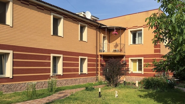Un immeuble à deux étages, doté d’une façade en briques et de nombreuses fenêtres.