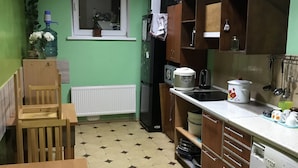 Une cuisine compacte équipée d’un lave-linge, d’un four à micro-ondes et d’un réfrigérateur.