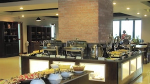 Un espace buffet avec différents stands de nourriture et un pilier en briques.
