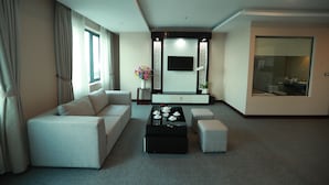 Un salon moderne avec un canapé, un pouf et une table basse.