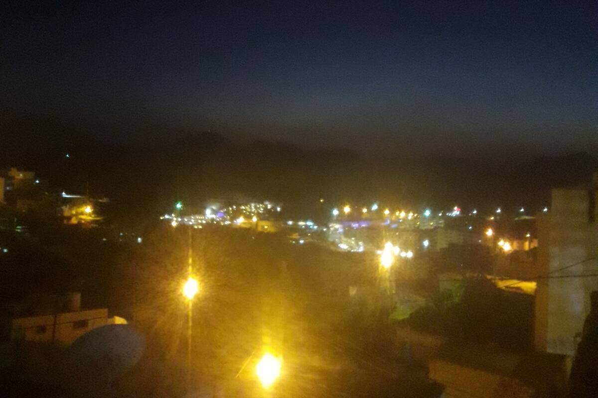 A nighttime view of a cityscape with streetlights and distant buildings.