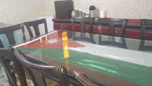 A dining table with a glass top and chairs around it. - Youth guest house (Wadi Musa)