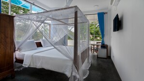Un dormitorio con cama con dosel, un armario de madera y un televisor montado en la pared.
