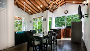 Comedor con techo de madera, ventanas amplias y cocina equipada con refrigerador y microondas.