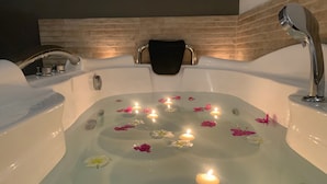 A bathtub with rose petals and candles. - ARYA Boutique Resort (Kiwengwa)