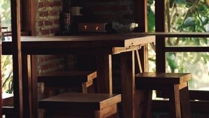 Un interior rústico con muebles de madera y pared de ladrillo.