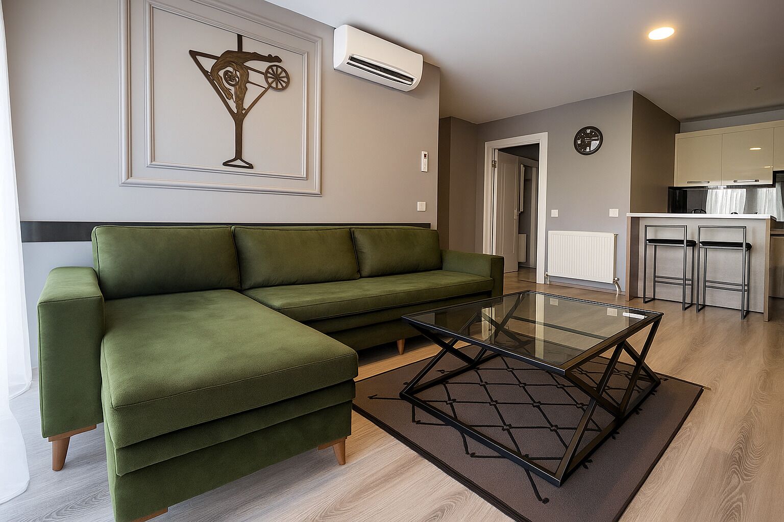 A modern living room with a green sofa, a glass coffee table, and a kitchen area in the background.