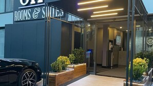 A hotel entrance with 'On4 Rooms & Suites' signage, a car parked outside, and a bollard in the foreground. - On4 Rooms & Suites (Istanbul)