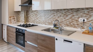A modern kitchen with a stainless steel sink, a built-in oven, and a dishwasher. - On4 Rooms & Suites (Istanbul)