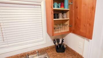 Una cocina con encimera de granito, pileta de acero inoxidable y muebles de madera.