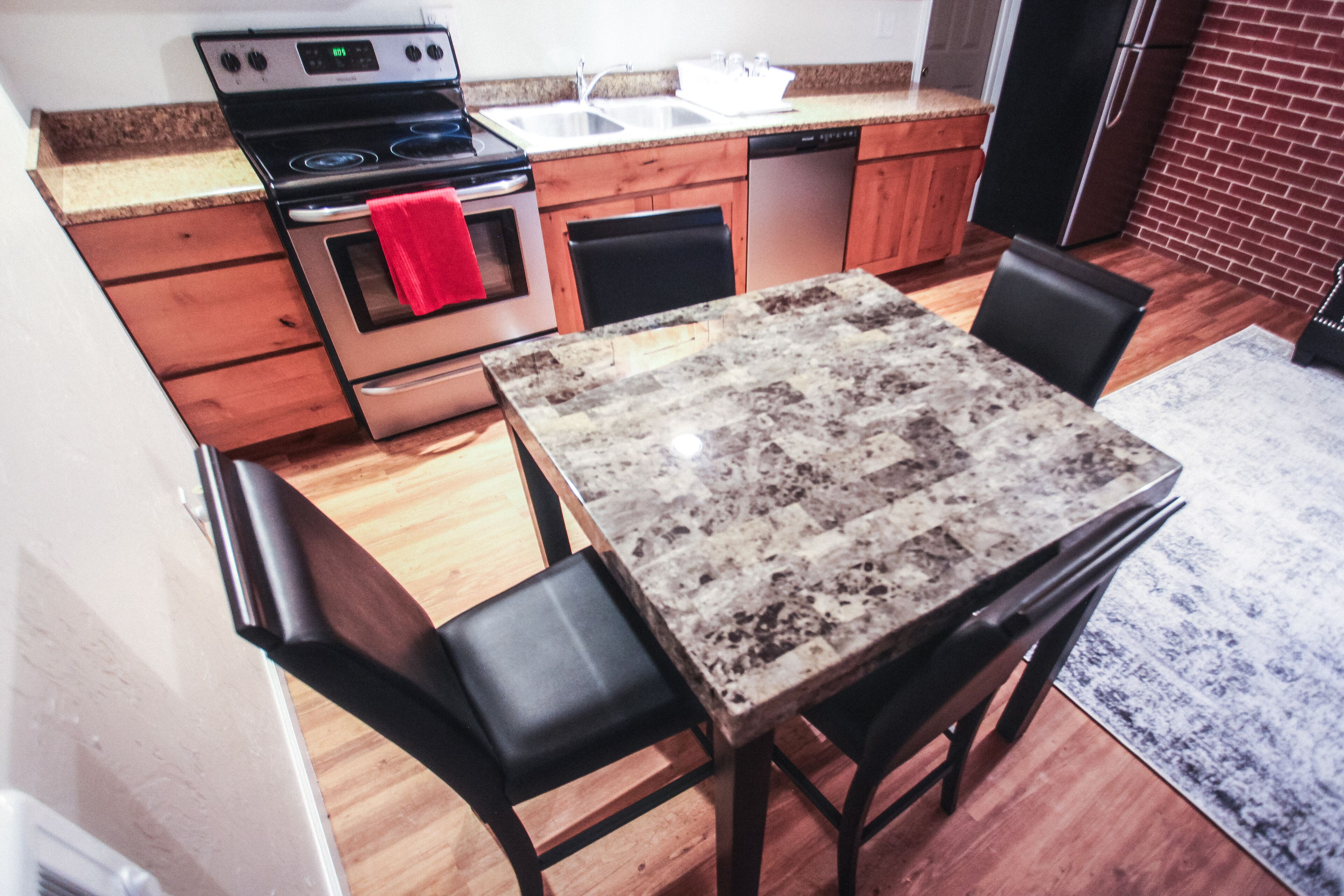 A kitchen with wooden cabinets, a granite countertop, a stainless steel stove, and a dishwasher.