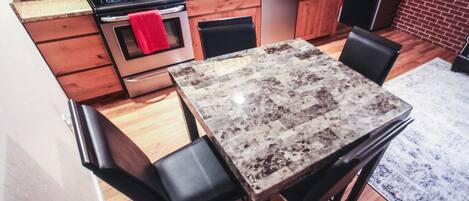A kitchen with wooden cabinets, a granite countertop, a stainless steel stove, and a dishwasher.