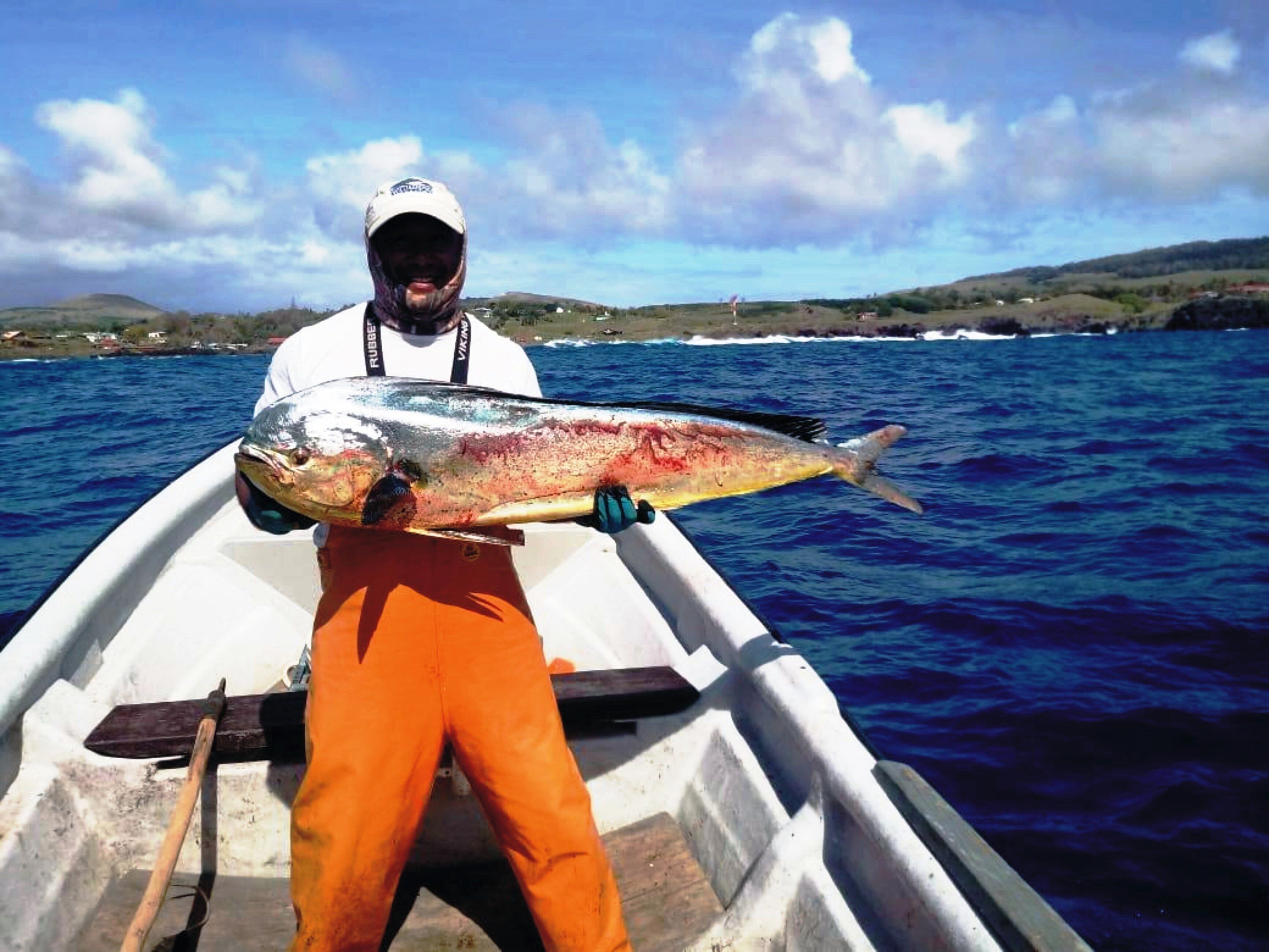 A person in a boat holding a large fish.