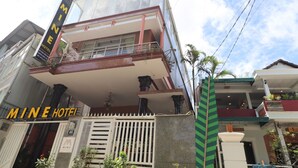 A hotel with a prominent sign reading "MINE HOTEL" and a balcony with railings.