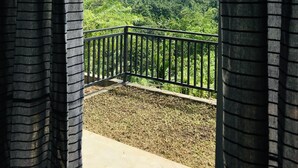 Un balcone con vista su un paesaggio verdeggiante e colline lontane.