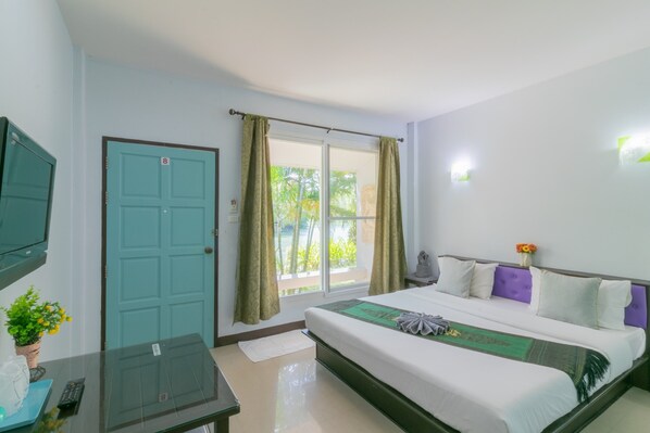 A hotel room with a bed, a TV, a window with curtains, and a door. - Chaiyo Resort (Wichit)