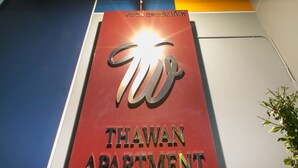 A sign for Thawan Apartment with a modern design and a bright light at the top. - Thawan Apartment (Satun)