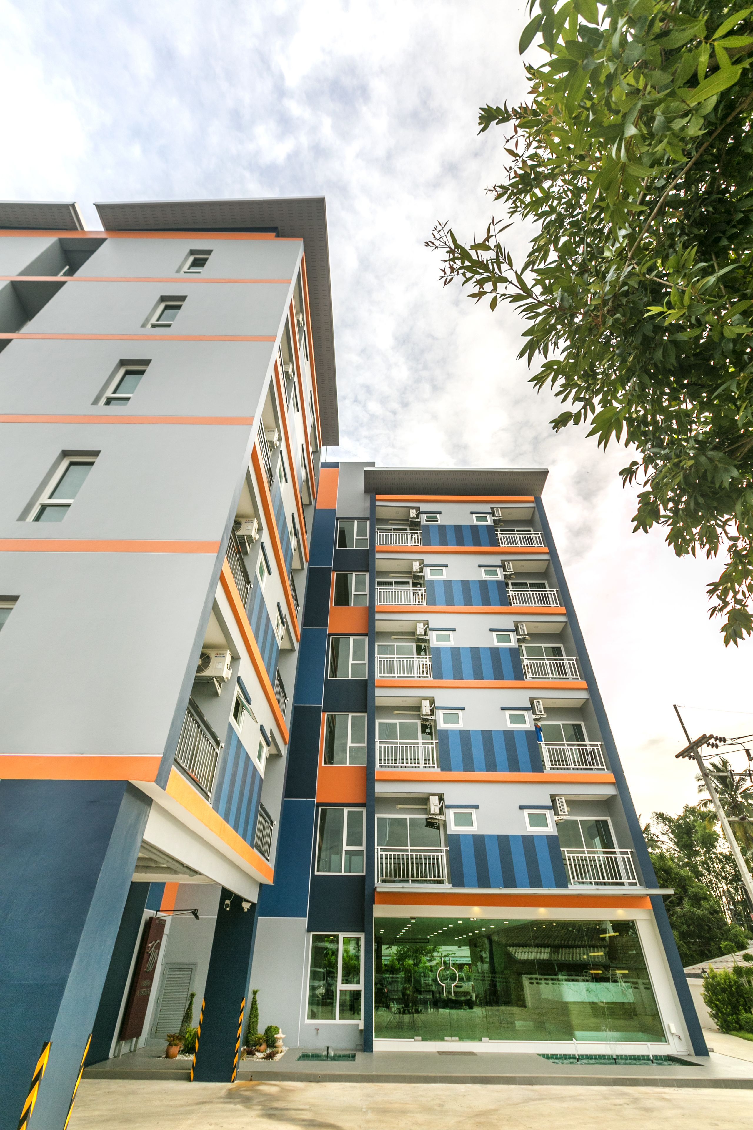 A multi-story building with balconies and a glass entrance.