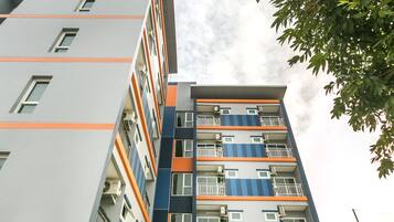 A multi-story building with balconies and a glass entrance.
