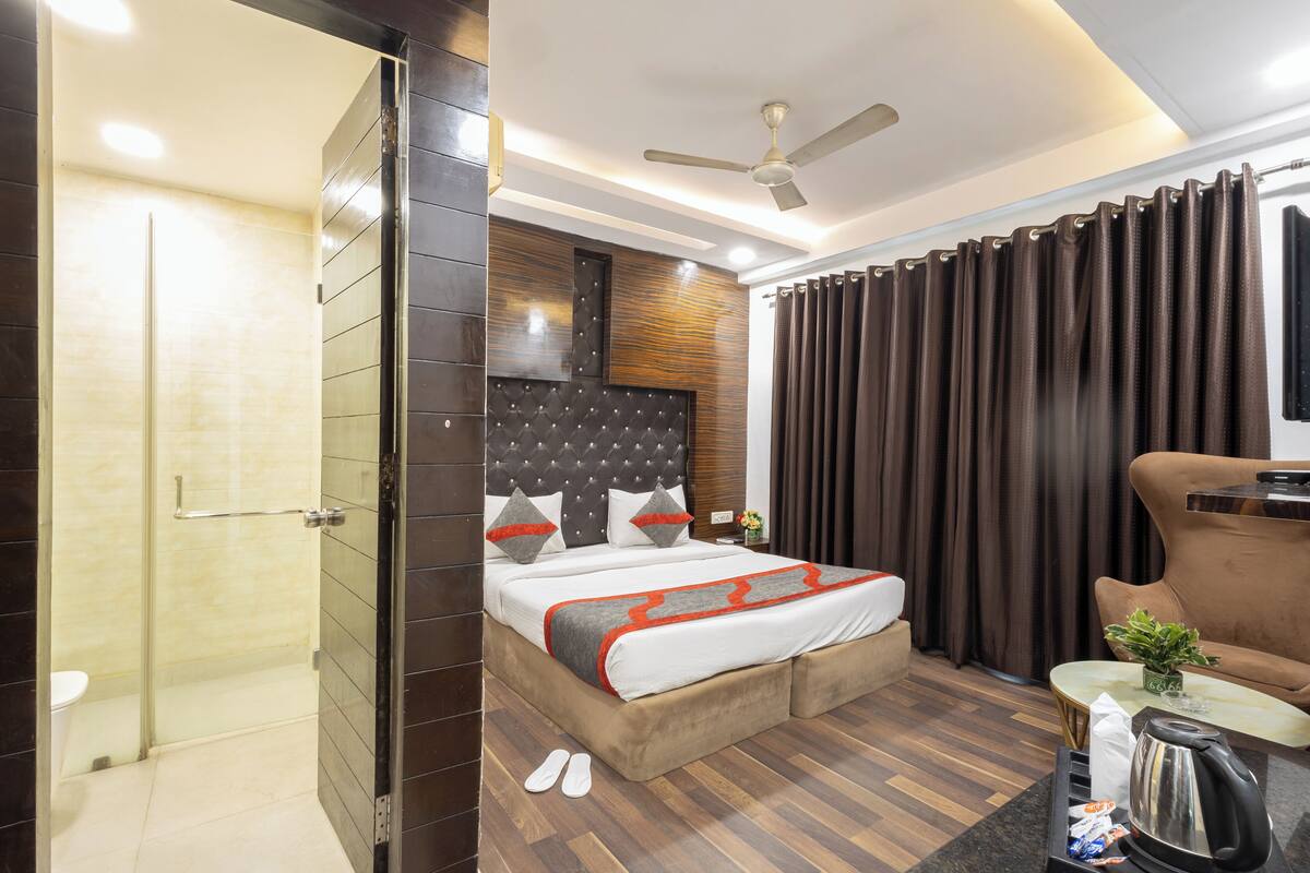 A modern hotel room with a large bed, a ceiling fan, a coffee table, and a sofa.