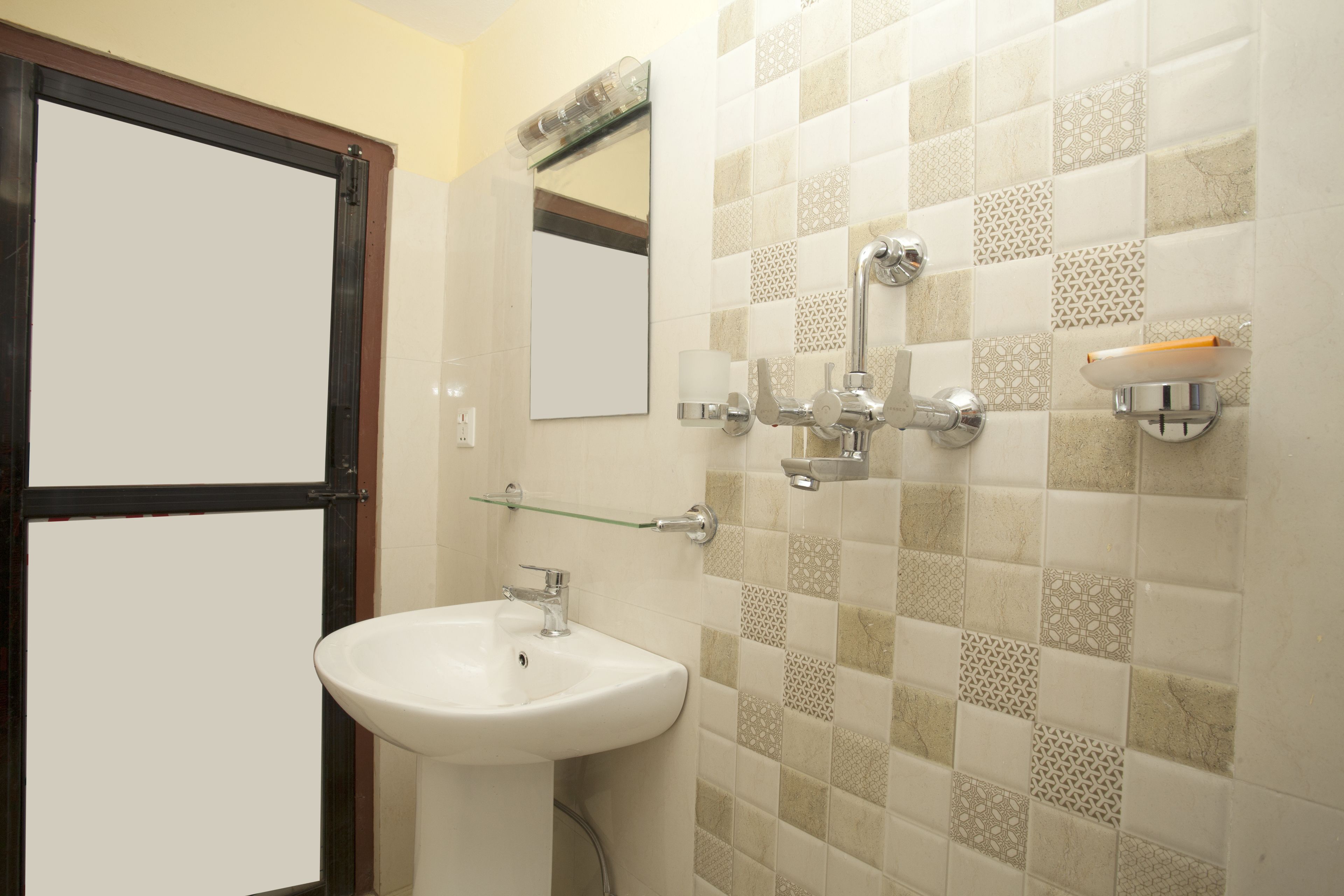 A bathroom with a sink, mirror, and tiled walls.