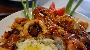 Prato de comida com diversos acompanhamentos e guarnições.