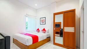Un dormitorio con cama, armario, espejo y ventana con cortinas.