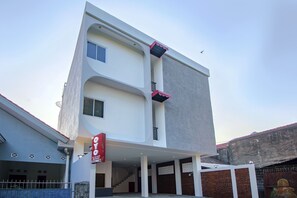 Un edificio moderno con un diseño arquitectónico único, que presenta una escalera central y varios balcones.