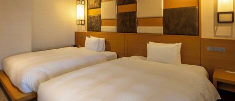 Een hotelkamer met twee bedden, houten hoofdeinden en een decoratief paneel aan de muur.