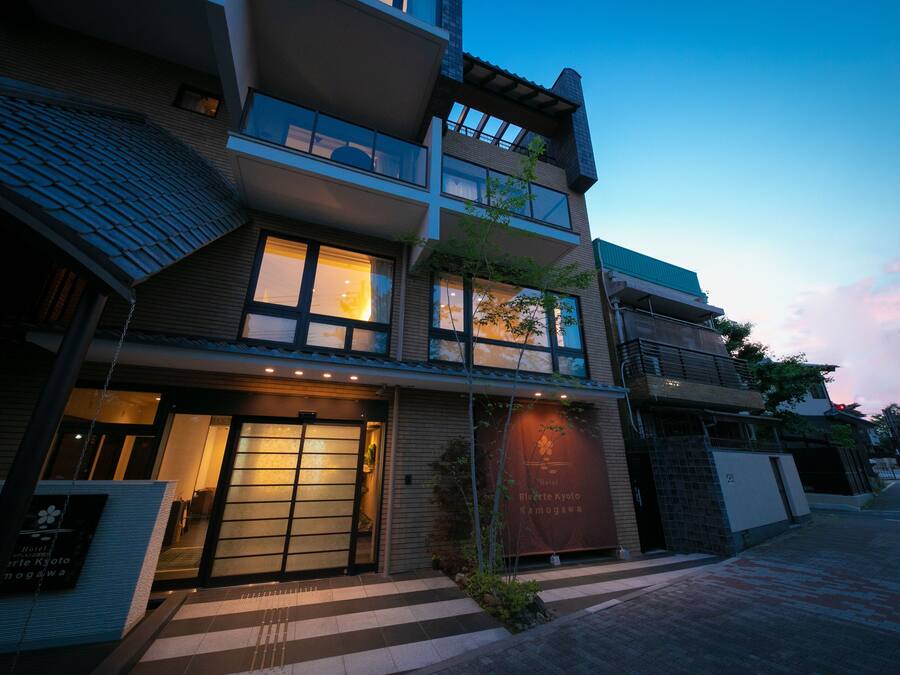 Un hotel a più piani con un ingresso dall'aspetto tradizionale, ampie finestre e un cartello che indica che si tratta dell'Hotel Riverside Kyoto.