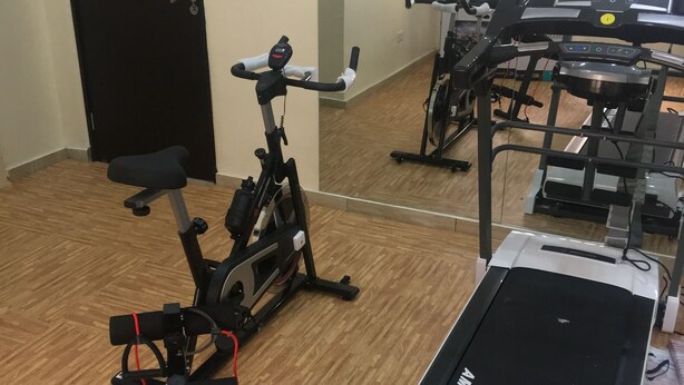 A gym with a treadmill, stationary bike, and exercise equipment. - House 19 Kodeland Holiday Home (Abuja)