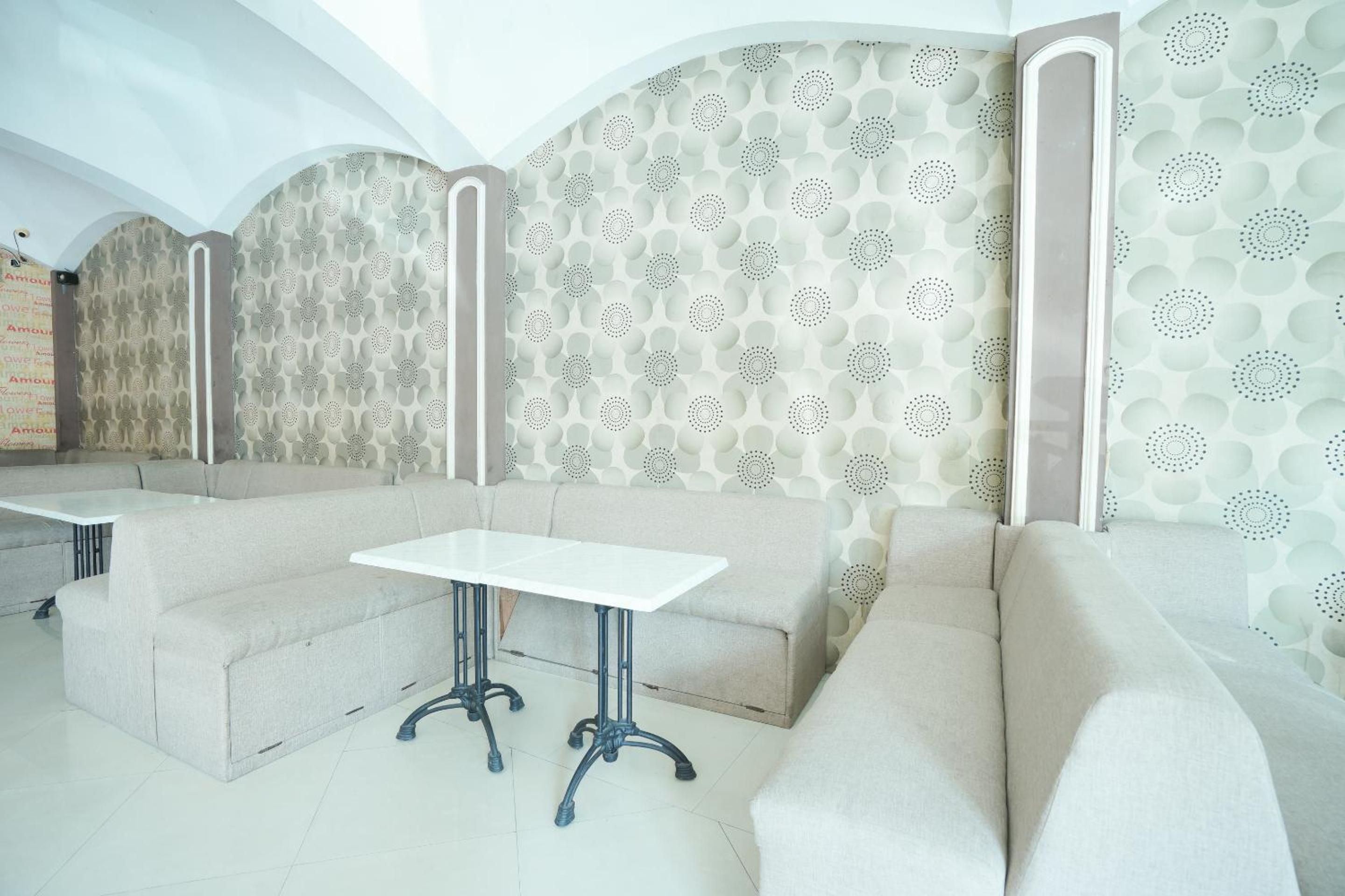 A modern interior with a sectional sofa, a small table, and patterned wallpaper.