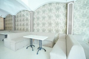 Un interior moderno con un sofá modular, una mesita y papel tapiz estampado.