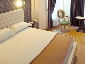 A hotel room with a large bed, a chair, a bedside table, and a telephone. - OYO 1239 Mojokerto Classic Homestay (Mojokerto)