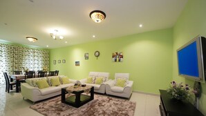 A living room with a sectional sofa, a coffee table, and a TV on a stand.