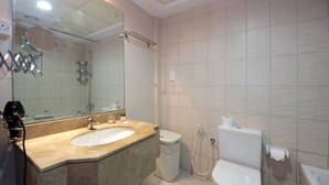 Un baño con lavabo, espejo, inodoro y ducha.