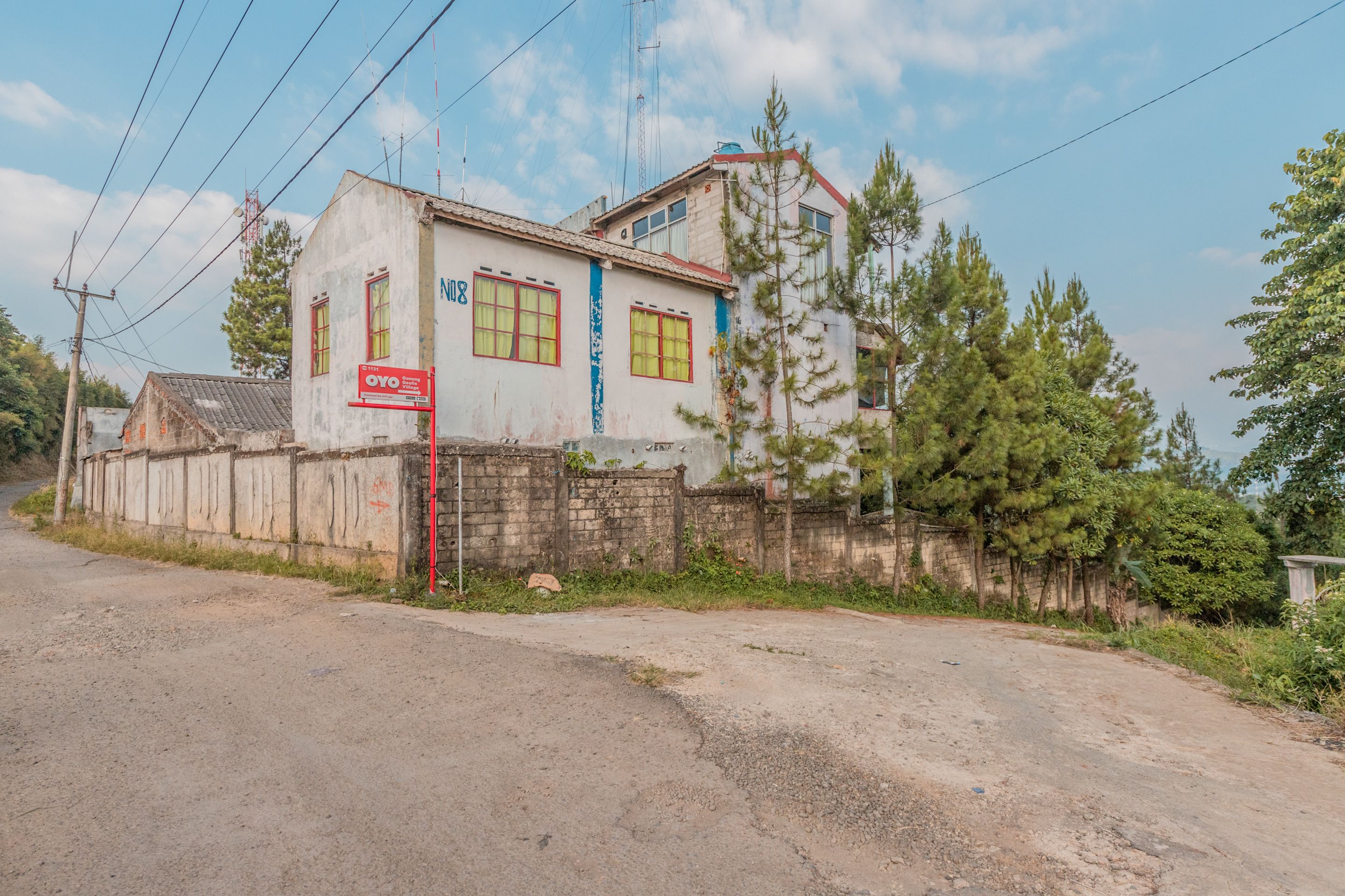 Un edificio de dos pisos con un letrero rojo en la planta baja.