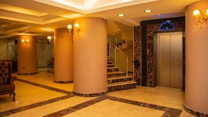 A hotel lobby with marble flooring, a staircase, and a reception desk. - Neccar Otel (Antakya)