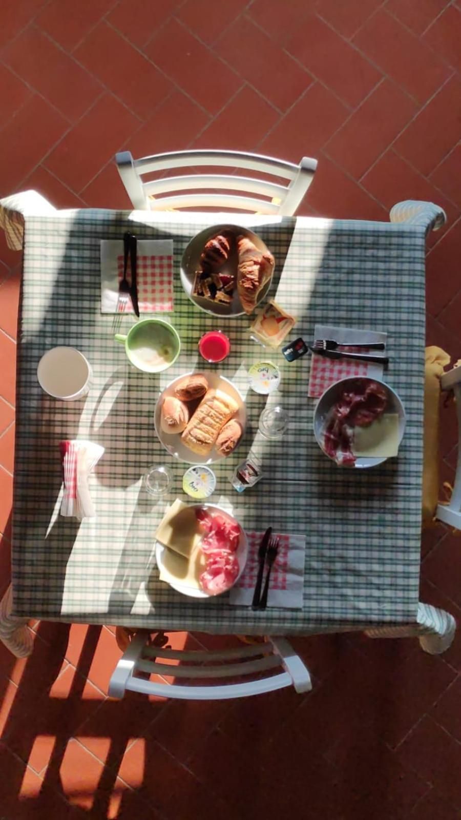 Een tafel met een geruit tafelkleed, bezaaid met verschillende gerechten en bestek, wat wijst op een maaltijd.