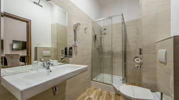 Un baño moderno con un lavamanos grande, una ducha con mampara de vidrio y un inodoro.