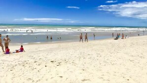 Ein Strand mit Menschen, die spazieren gehen und schwimmen.
