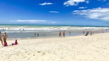Na praia, areia branca, barracas de praia (sobretaxa)