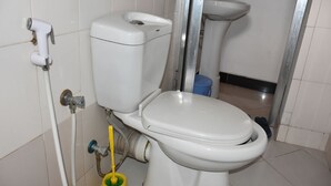 A bathroom with a toilet, bidet, and a hand dryer. - Dar eco backpackers (Dar es Salaam)